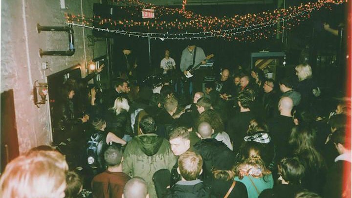 Crowded indie rock show in a small venue with string lights