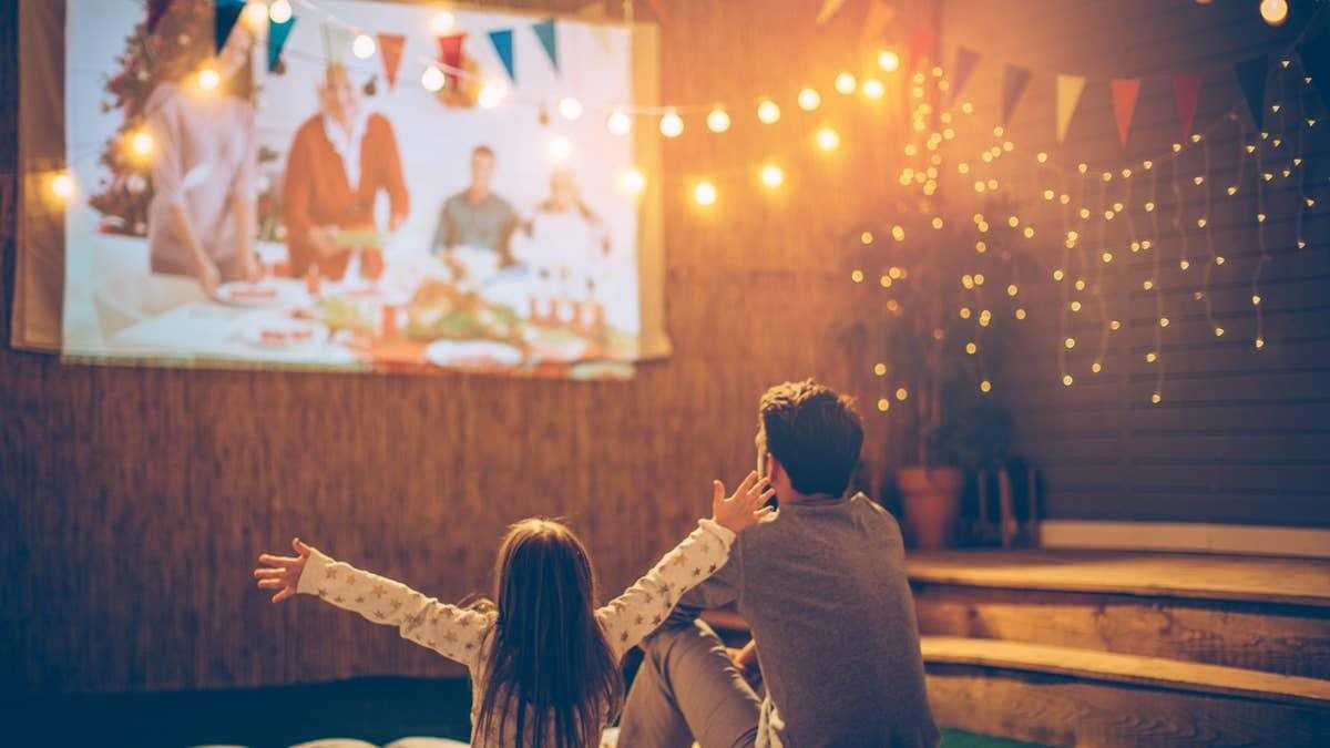 A family watching an outdoor movie together at night